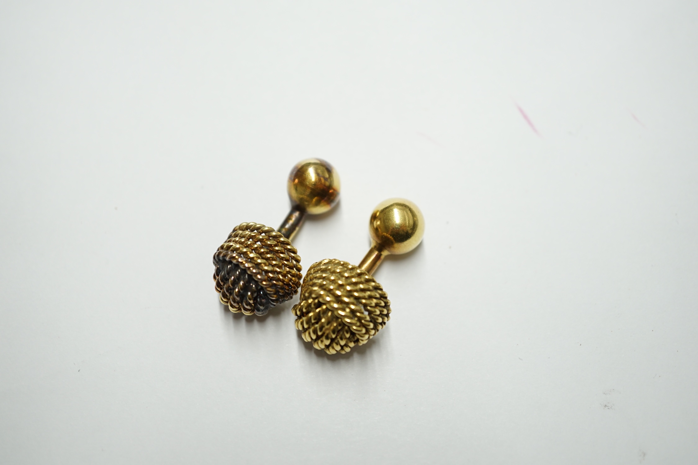 A French 18ct gold cufflink of rope twist design with ball terminals, 9.4 grams and an unmarked companion. Condition - fair